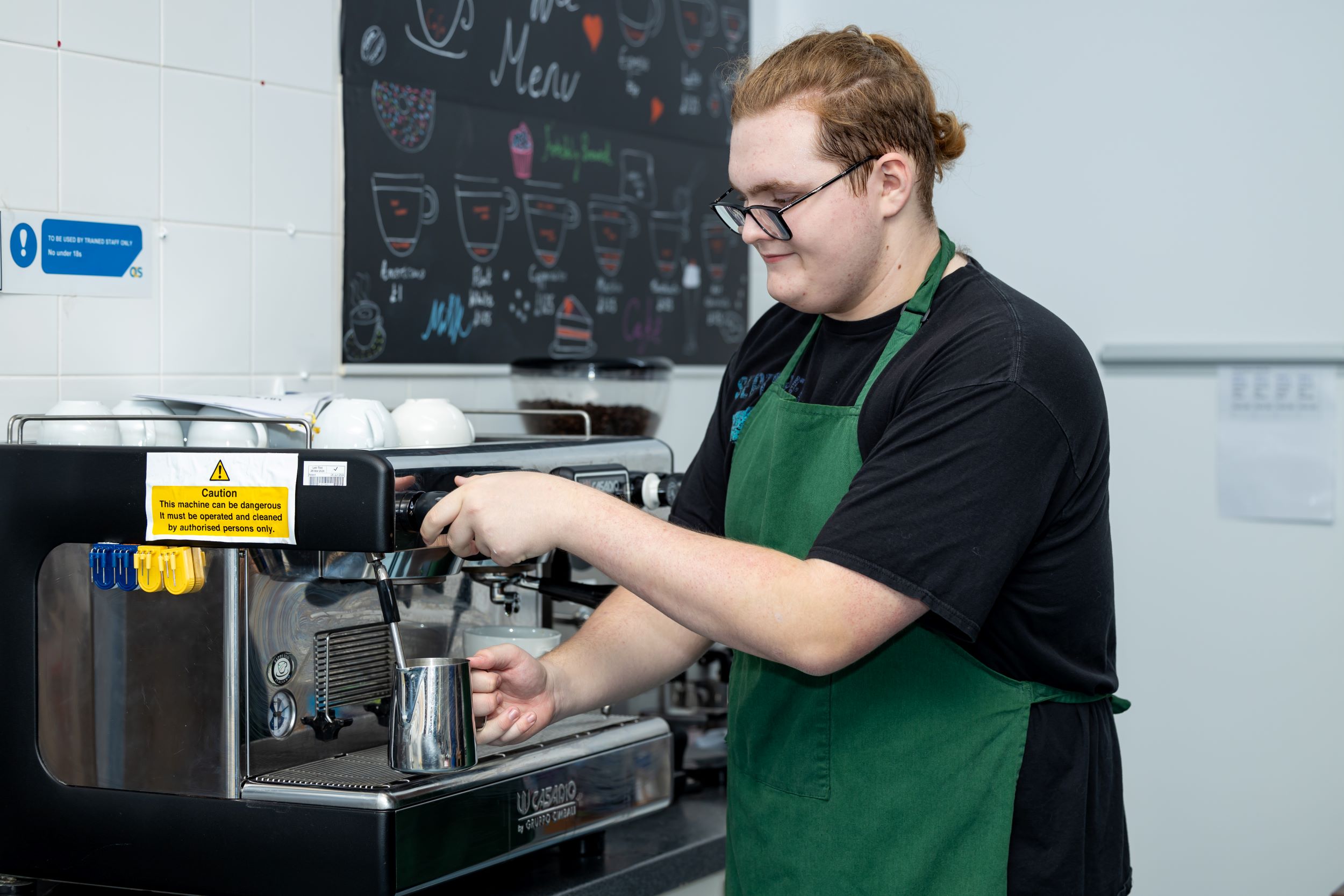 A student using the barista coffee machine in QA Café 