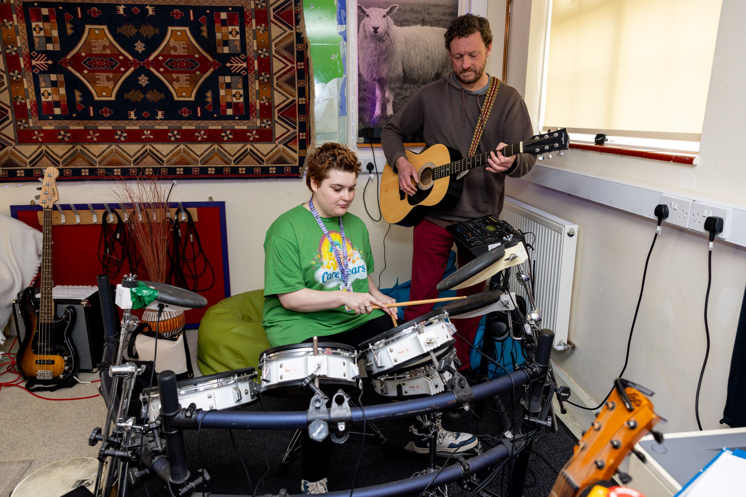 Music Wellbeing Practitioner and a student play instruments in the Music Wellbeing Room 