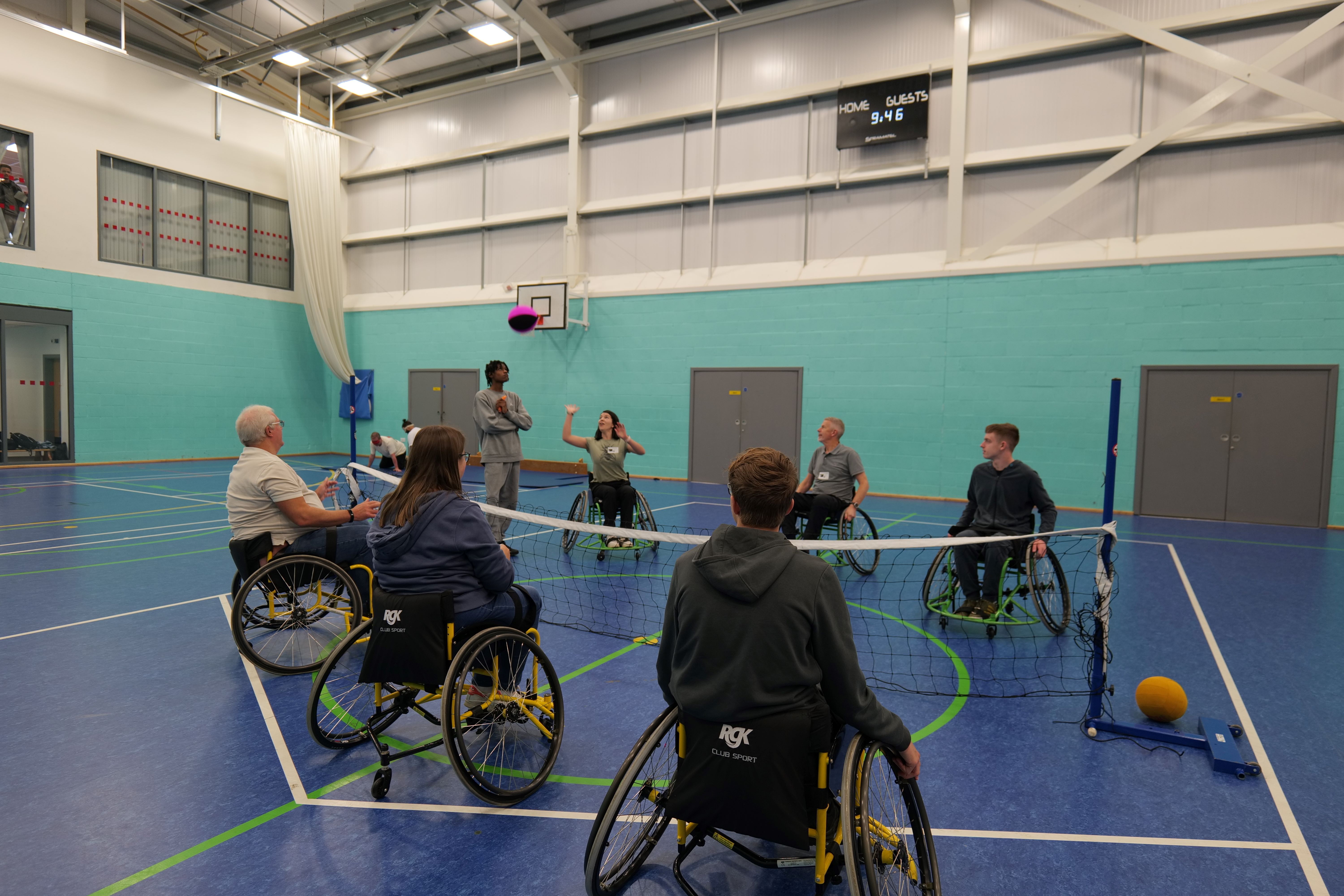 Visitors and students playing wheelchair volleyball