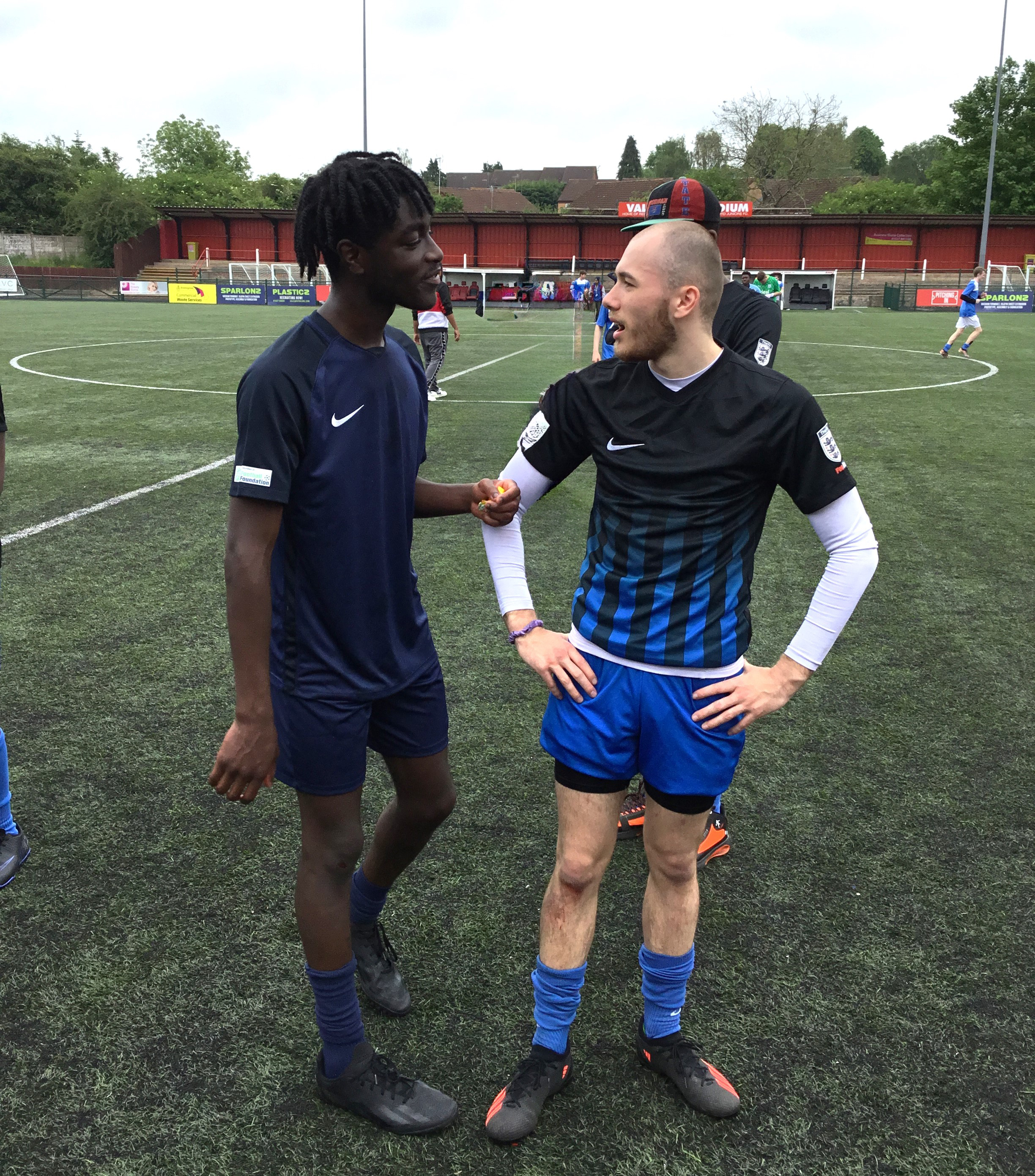 Two students talking in football kits