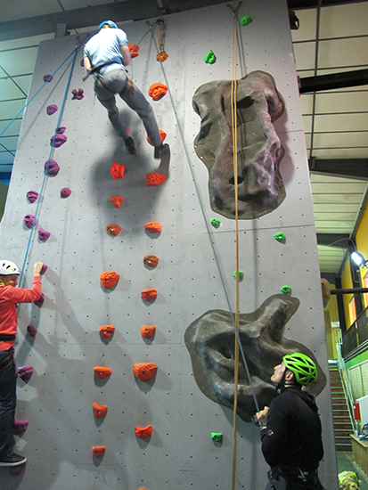 Students scale a climbing wall