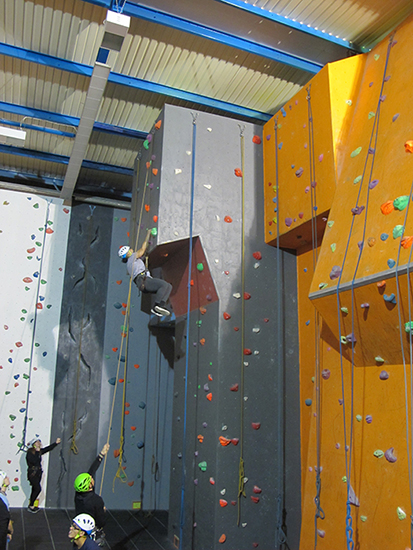 Student reaches the top of a climbing wall