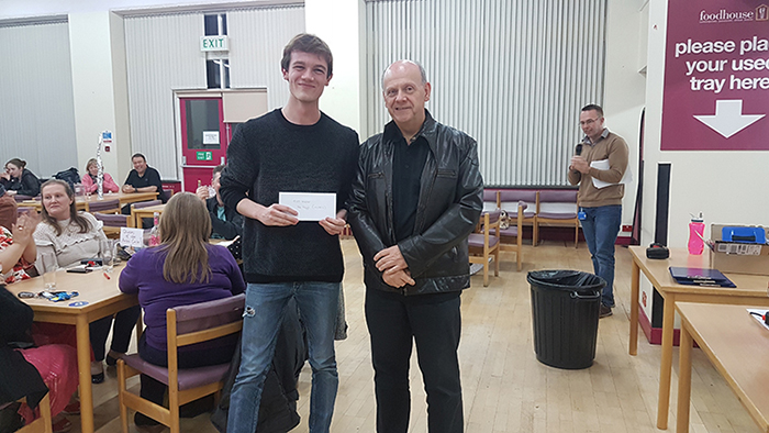 Curry & Quiz Night winning team representative collecting prize from College principal Hugh Williams