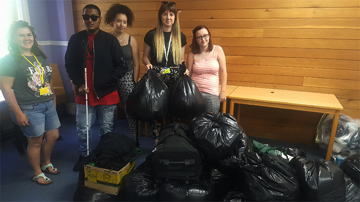 Students and staff pose for a photo with all of the collection bags the students amassed