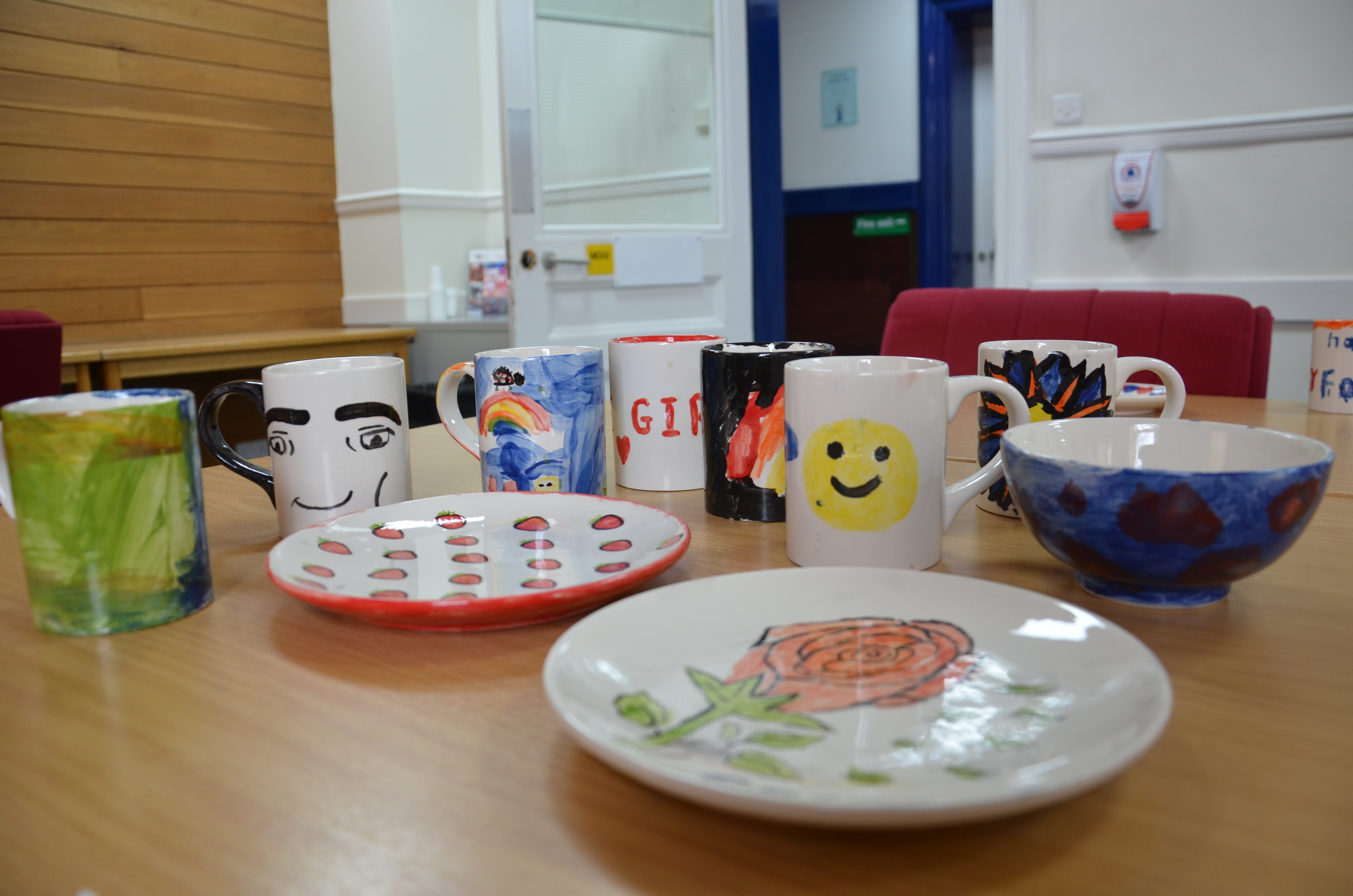 Table with painted mugs and plates