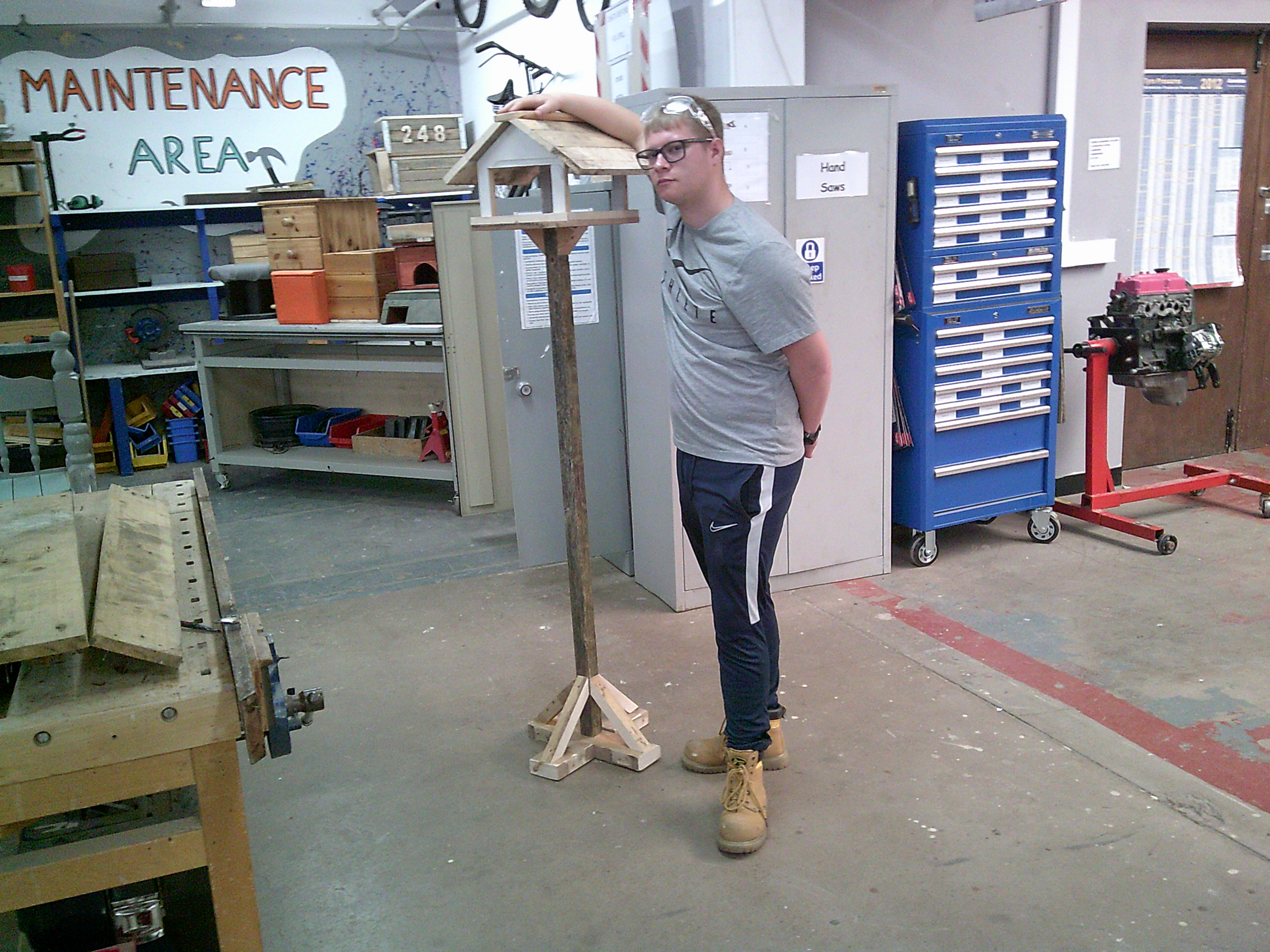 Josh standing next to a bird box in the workshop