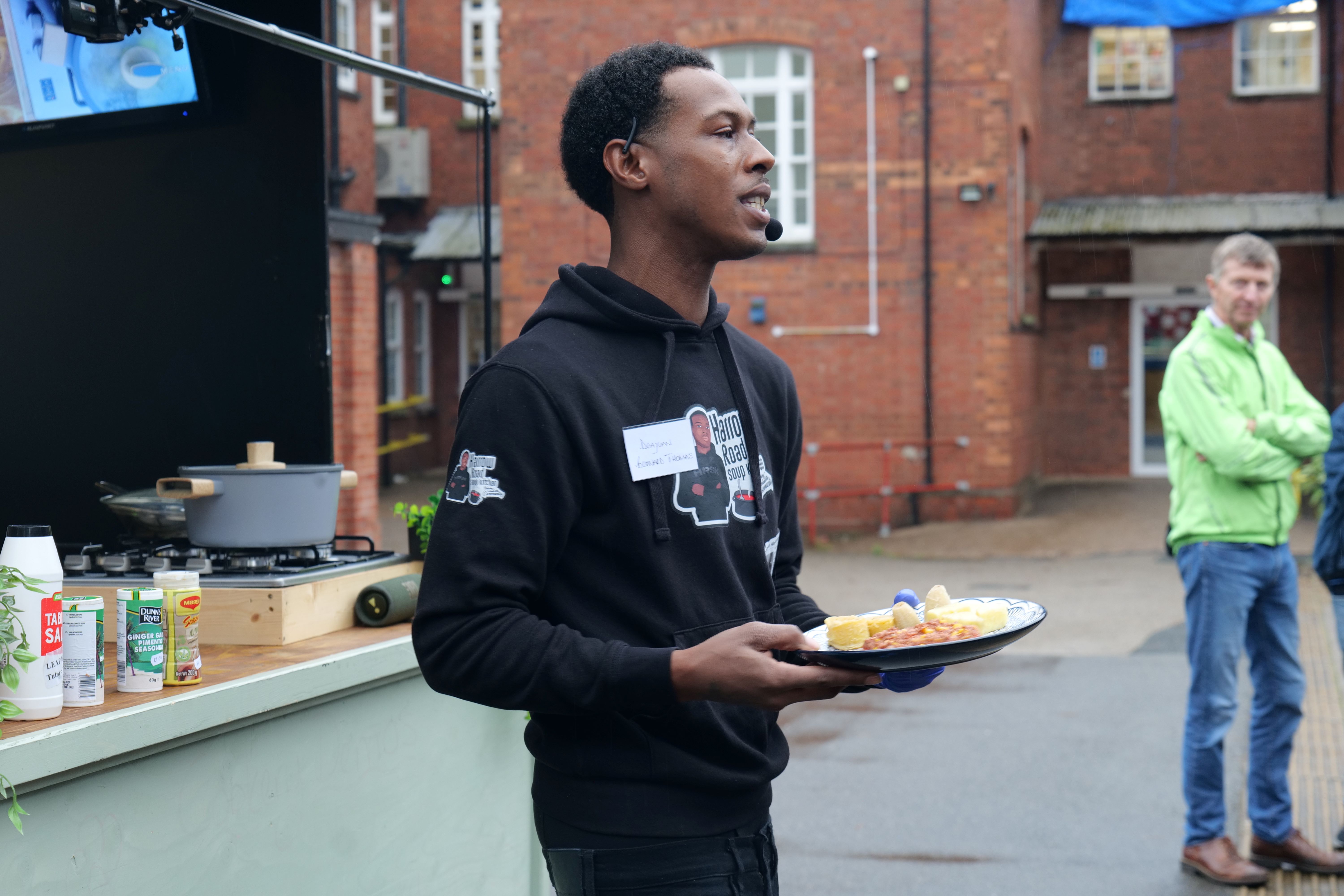 Harrow Soup kitchen staff showing a meal to students and families