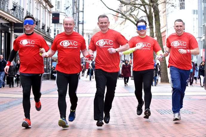 Derek, James and their guide runners run with Dave through a Birmingham street