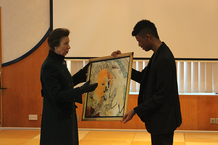 QAC student Konnor presenting HRH The Princess Royal with a painting created by him