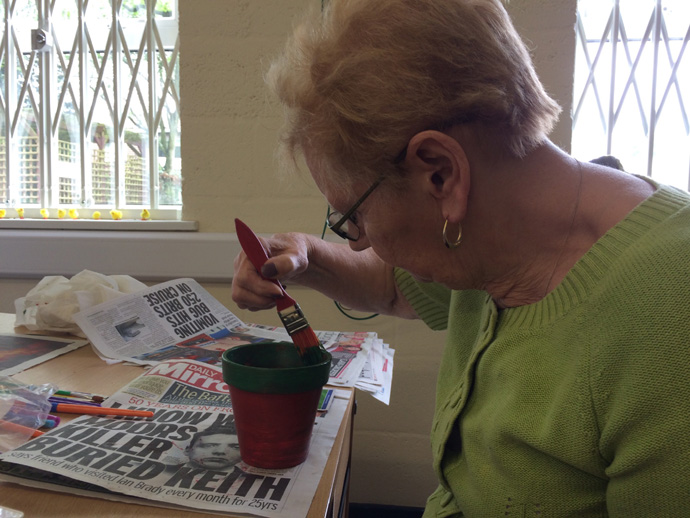 Lady decorating a plant pot during the workshop