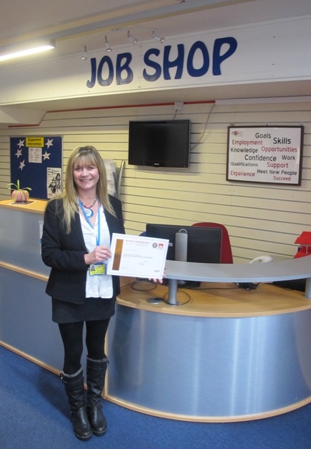 Fiona Bilsborough stands holding Bronze Standard accreditation award