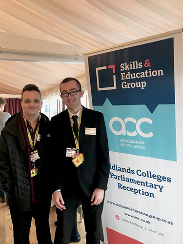 QAC Students Adam and Connor stood in front of an event banner at the Celebrating Midlands Colleges reception