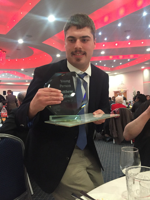 Matthew holding his award