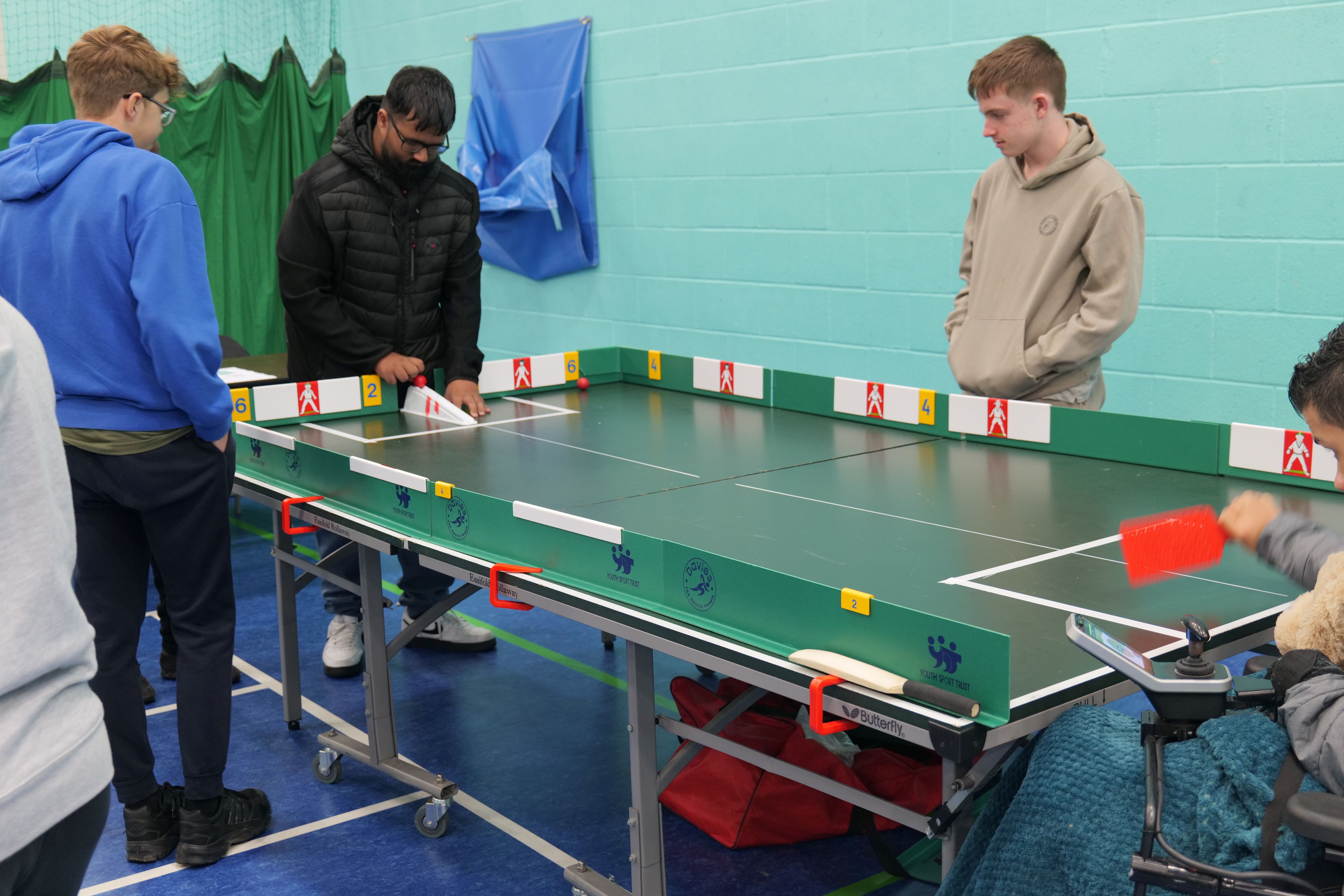 Image of 4 students playing table top cricket