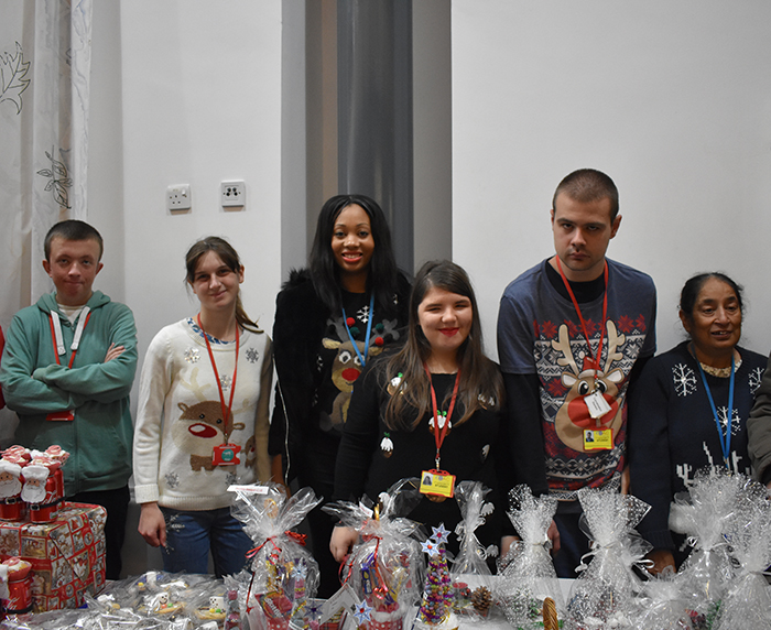 Students and staff pose for photo behind their stall at the Christmas Fayre