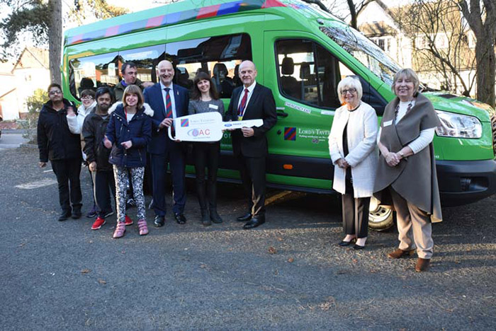 PFL Green and visitors with cardboard key in front of the minibus