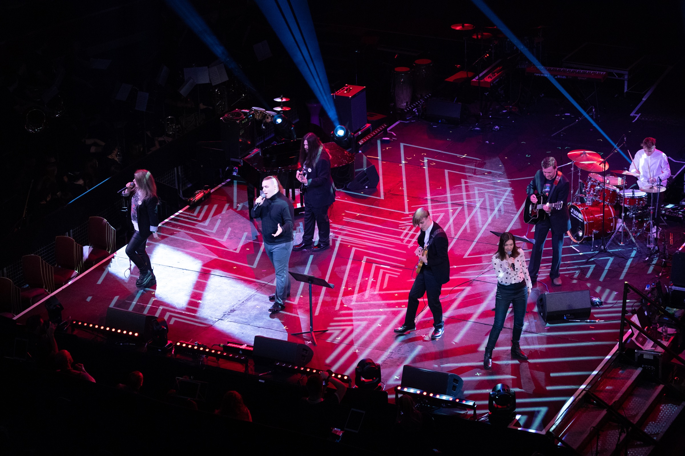 An overhead view of all the QA Collective band members performing on stage 