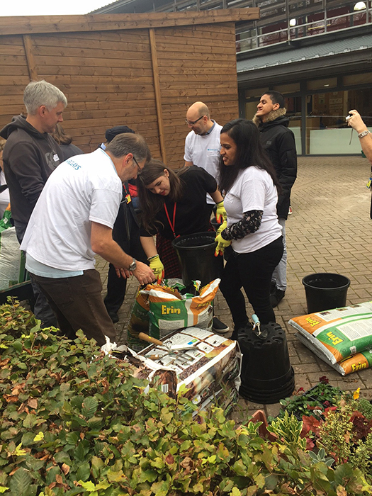 QAC Students and Barclays staff filling buckets with compost