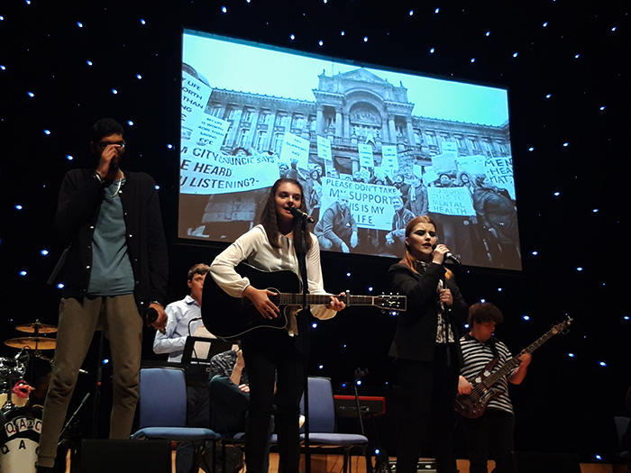 Members of the QAC Collective perform one of their chosen songs on stage at the Birmingham Town Hall