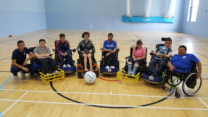 QAC students and WBA coaches posing for a photo during Powerchair Football training