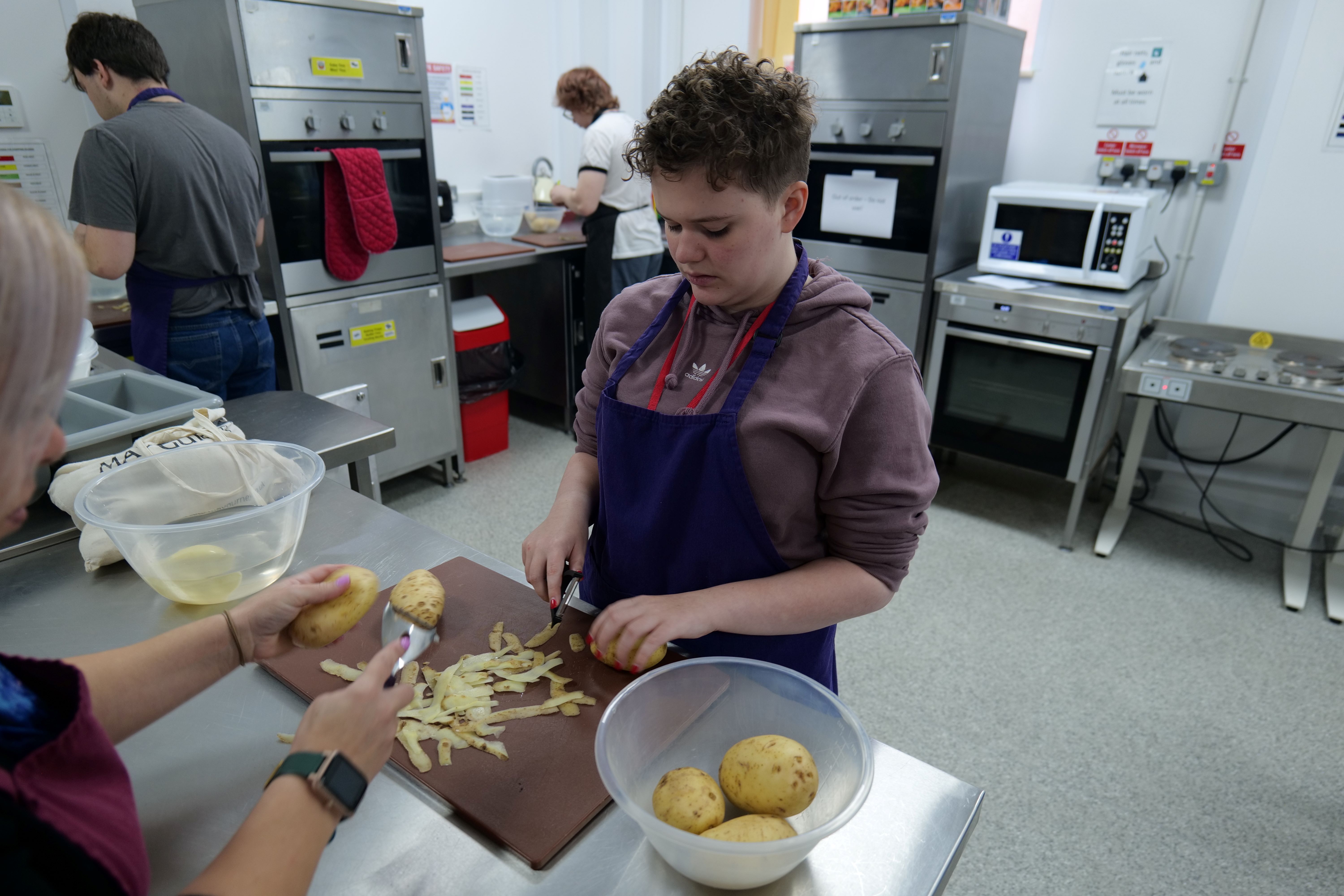 Hospitality student peeling a potato