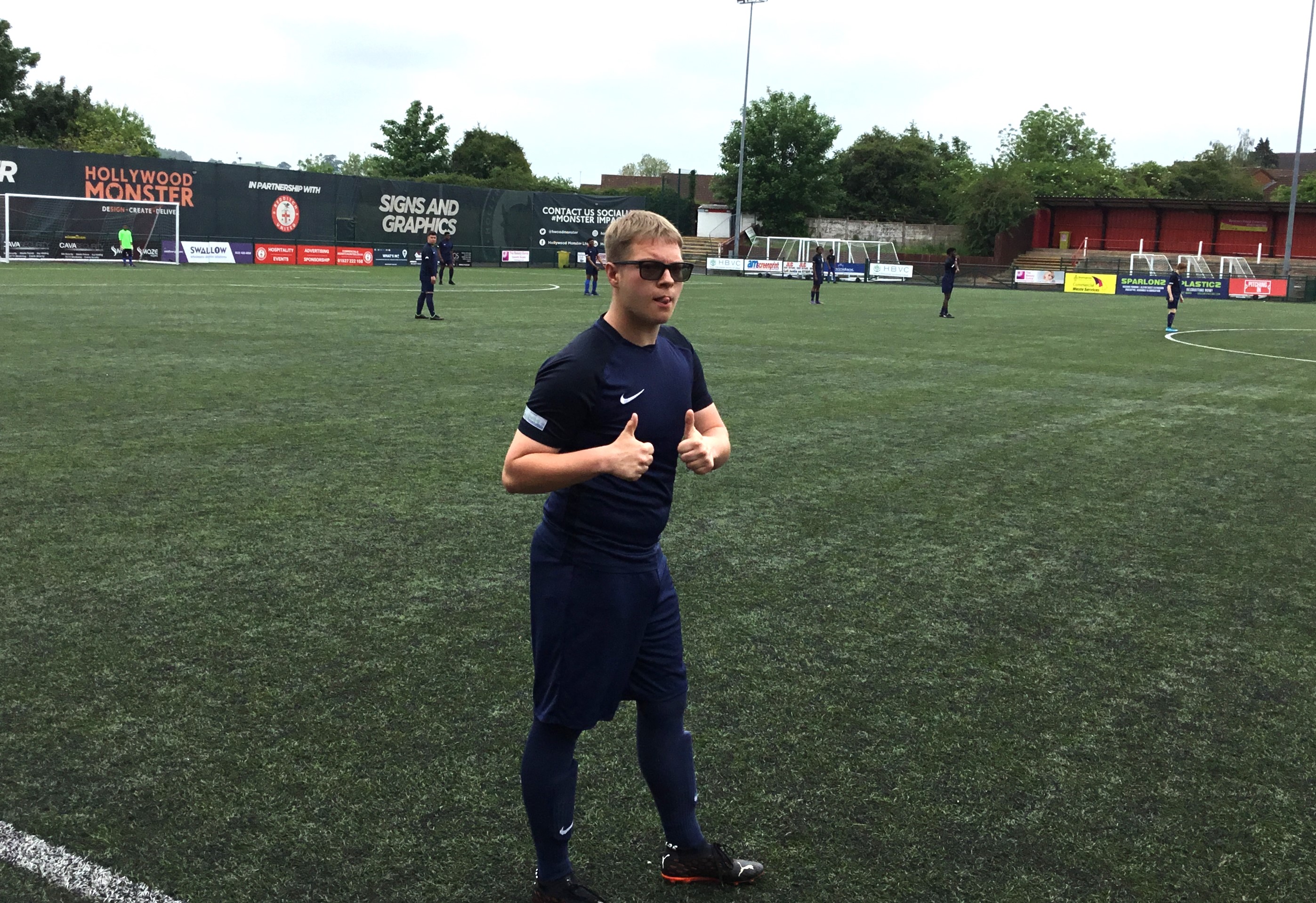 Student holding their thumbs up whilst on the football pitch