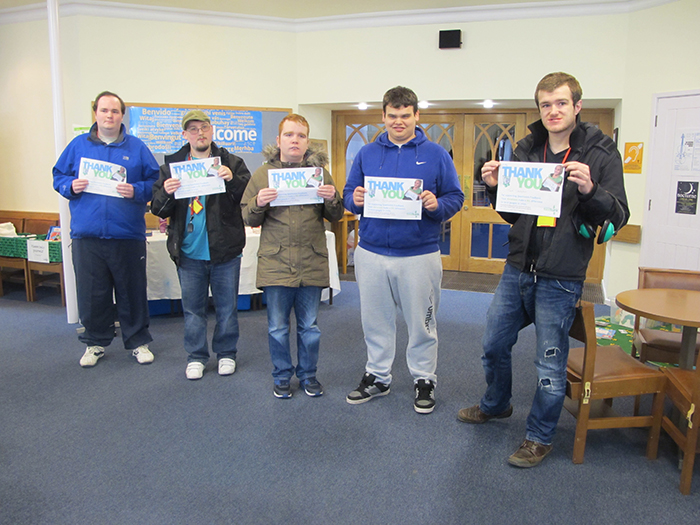 Students holding certificates following donation