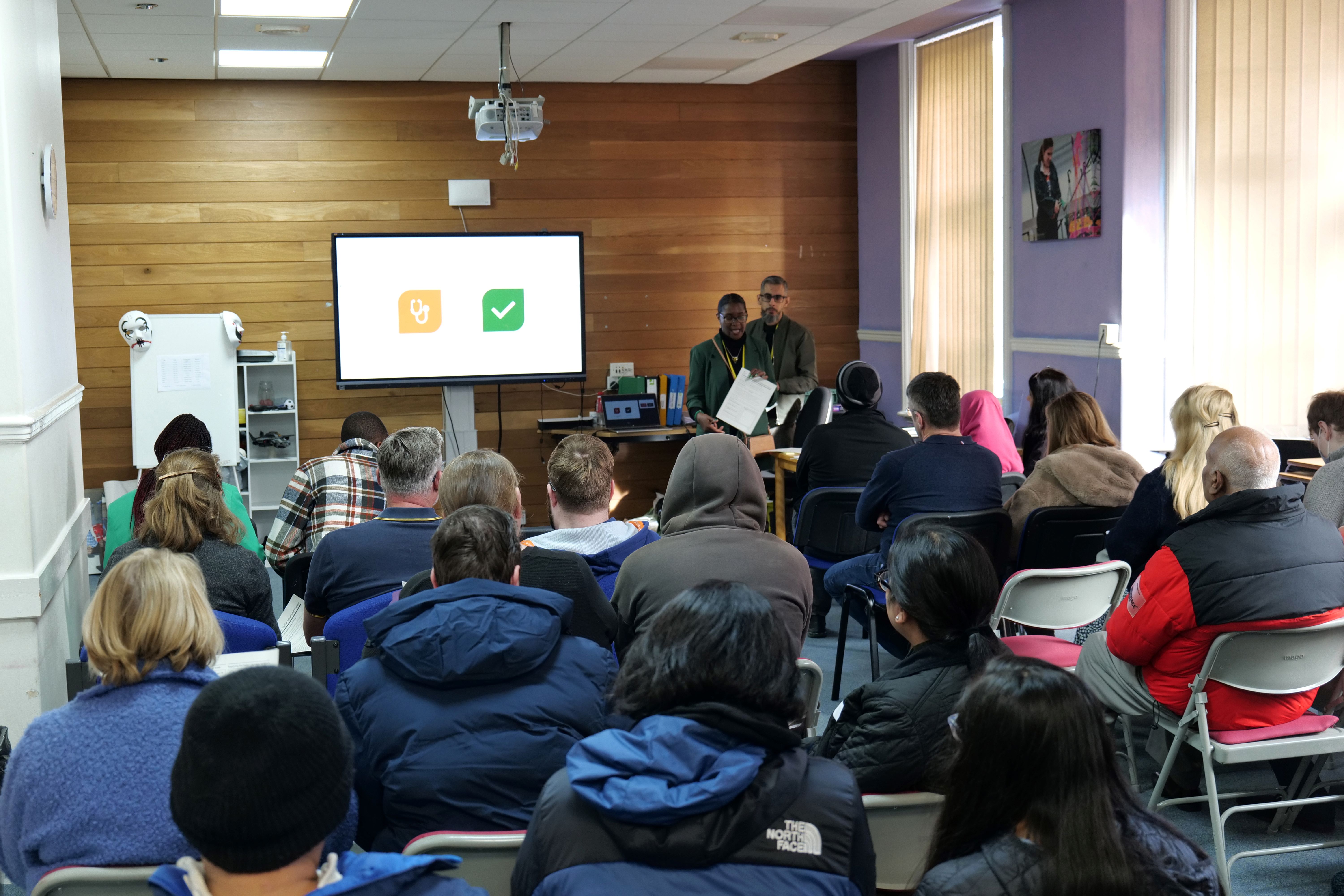 Image of a Next steps talks with two exhibitors at the front of a room with parents and students seated.