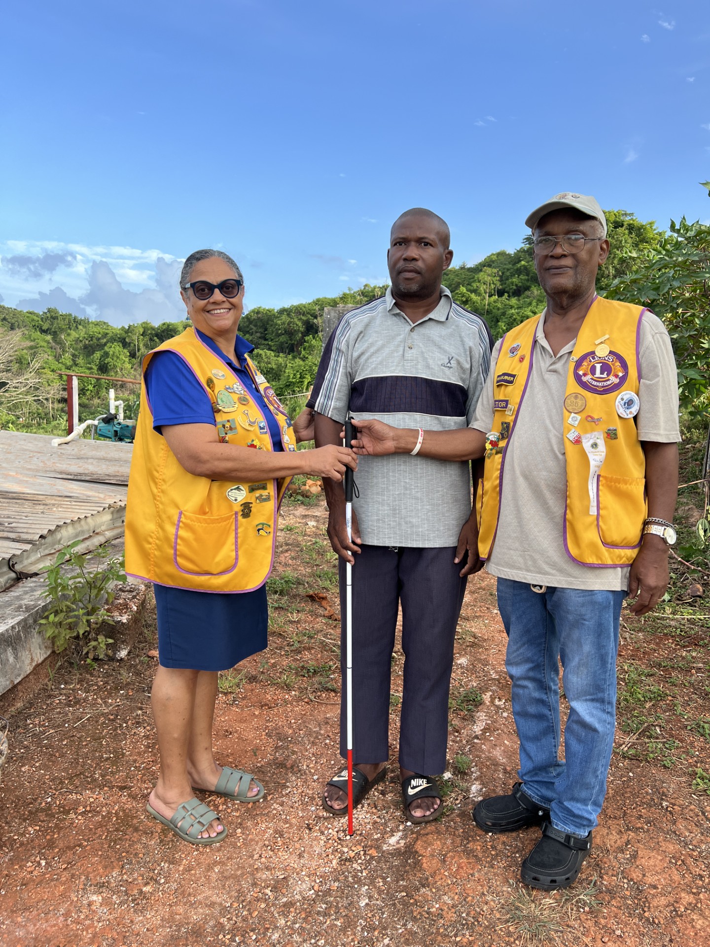 Image of 2 St Lions club members giving a cane to a citizen