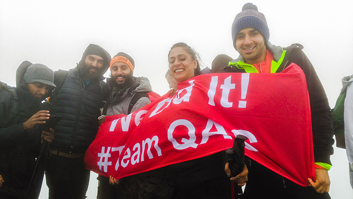 Inspire2binspired team with the #TeamQAC flag at the summit of Mount Snowdon