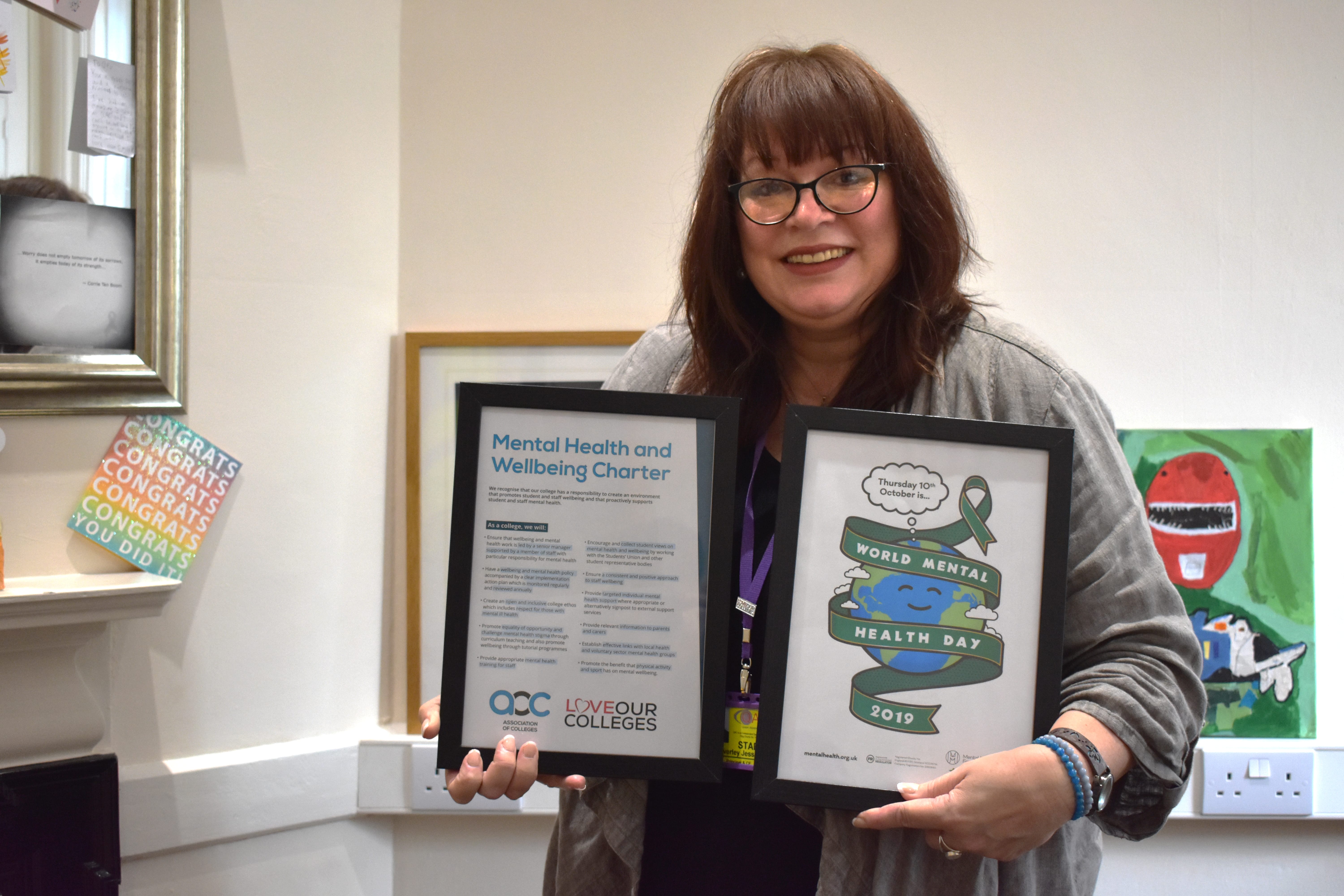 Bev Jessop holding two framed documents