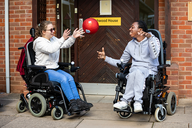 Residential students throw a ball to each other outside